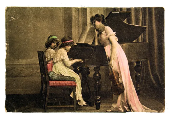 Frau mit Geige in den Händen, die in der Nähe des Klaviers steht — Stockfoto