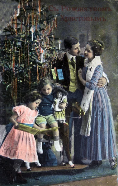 RUSIA - CIRCA 1913: La postal impresa en Rusia muestra a la familia cerca del árbol de Navidad, alrededor de 1913 —  Fotos de Stock