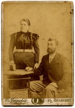 RUSSIA - CIRCA the end of 19 - early 20 century: An antique photo shows couple, Lugansk, Russian Empire Russian text: Umanskiy (photographer), Lugansk clipart