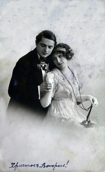 Чоловік обіймає плечі жінкою, яка тримає квіти — стокове фото