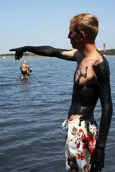 Ung man täckt med lera i salt lake — Stockfoto