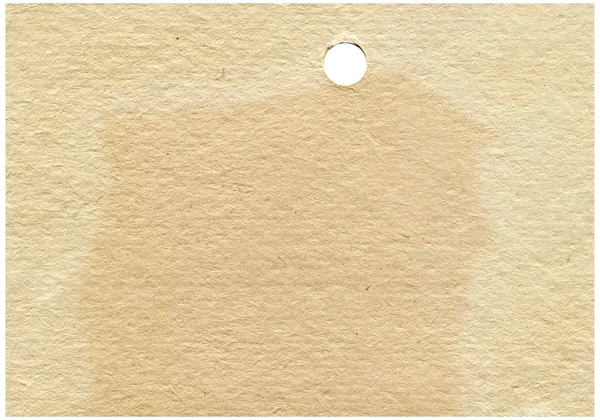 Old yellowed paper with a round hole — Stock Photo, Image