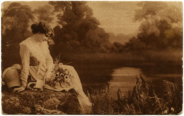 Грустная женщина лежит на берегу реки — стоковое фото