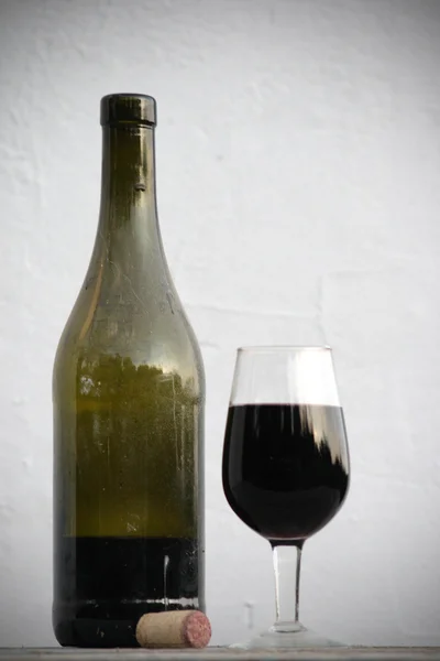 Fles rode wijn en wijnglas — Stockfoto