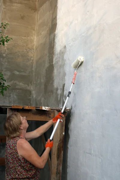 Kvinna målar huset — Stockfoto