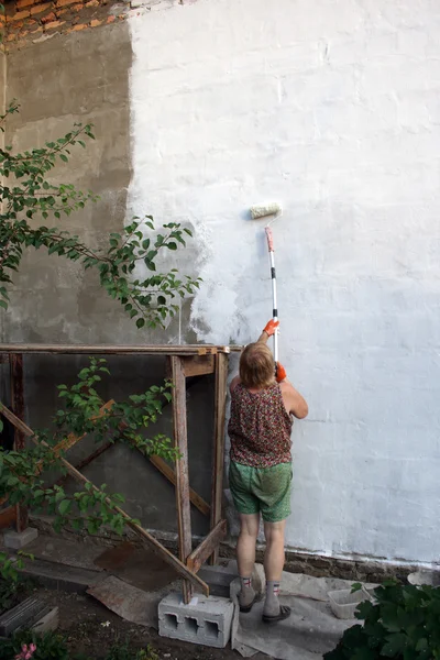 Woman paints house
