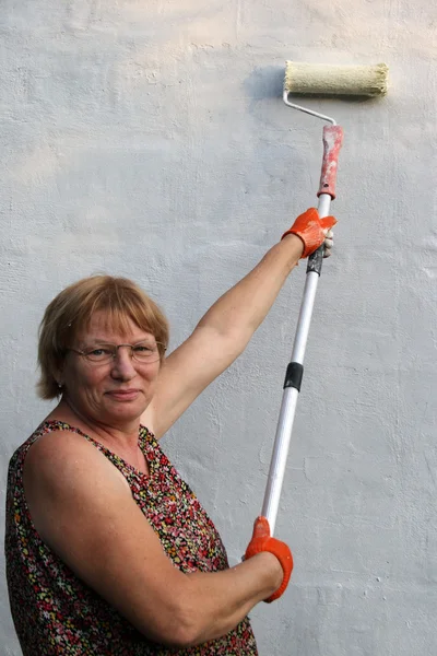 Woman paints house — Stock Photo, Image
