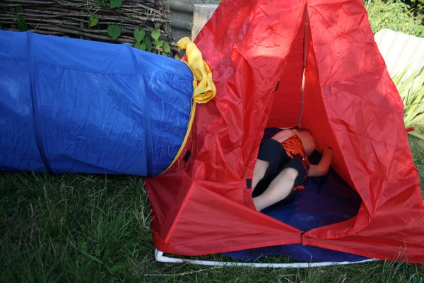 Rapaz numa tenda vermelha — Fotografia de Stock