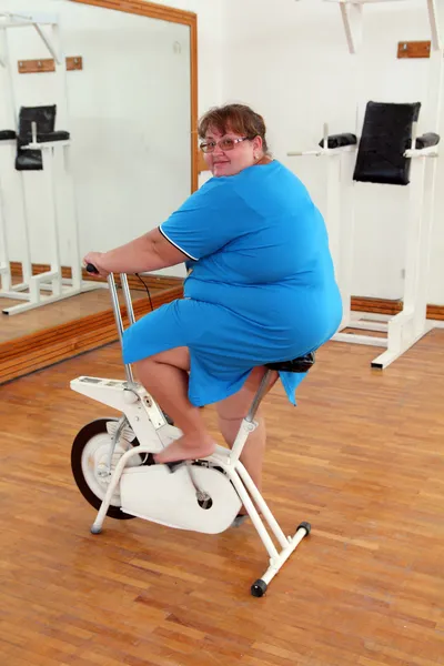 Sovrappeso donna esercizio in bicicletta — Foto Stock