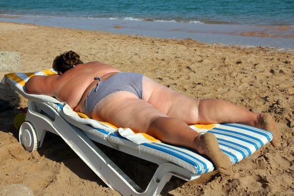 Overweight woman sunbathe on beach — Stock Photo, Image