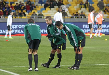 Referee and his assistans warm up before game clipart