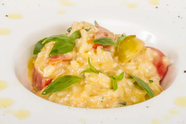 Foto de delicioso plato de risotto con hierbas y tomate en blanco b —  Fotos de Stock