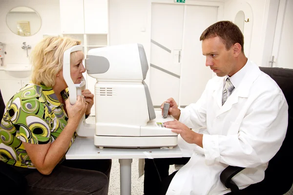 医師は、眼科クリニックで患者を調べる — ストック写真