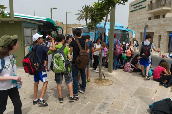 Studenter väntar på gatan för en buss Stockbild