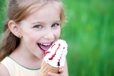 Beautiful little girl eats ice-cream clipart