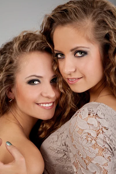 Duas meninas gêmeas, isoladas no fundo cinza — Fotografia de Stock