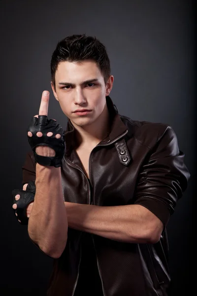 Angry handsome young man is showing a middle finger — Stock Photo, Image