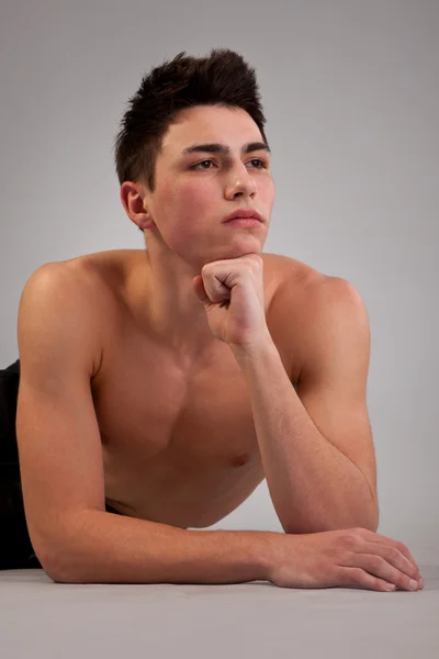 Здоровый мускулистый молодой человек на сером фоне — стоковое фото