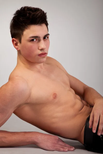 Saludable joven musculoso sobre fondo gris —  Fotos de Stock