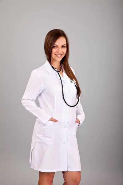 Młoda i piękna pielęgniarka na szary — Zdjęcie stockowe