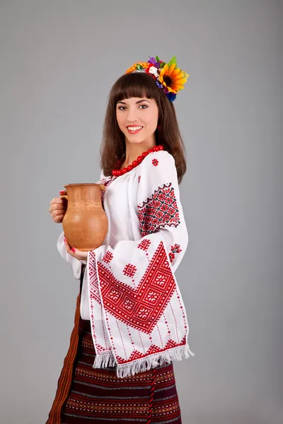 Mulher atraente usa ucraniano está segurando um jarro vestido nacional — Fotografia de Stock