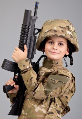 Young boy dressed like a soldier with rifle clipart