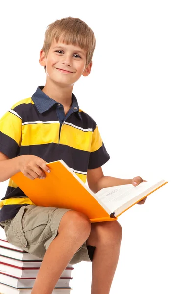 Schoolboy est assis sur des livres — Photo