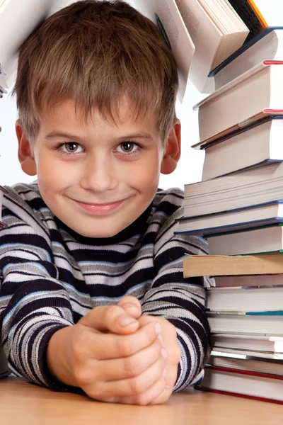 Schooljongen en een hoop boeken geïsoleerd op een witte achtergrond — Stockfoto