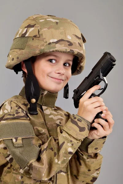 Elinde silah olan bir asker gibi giyinmiş genç çocuk — Stok fotoğraf