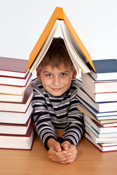 Schoolboy and a heap of books — Stock Photo, Image