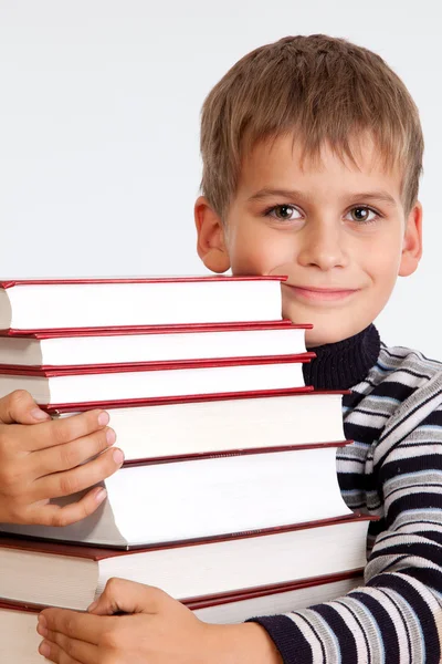 Un écolier et un tas de livres — Photo