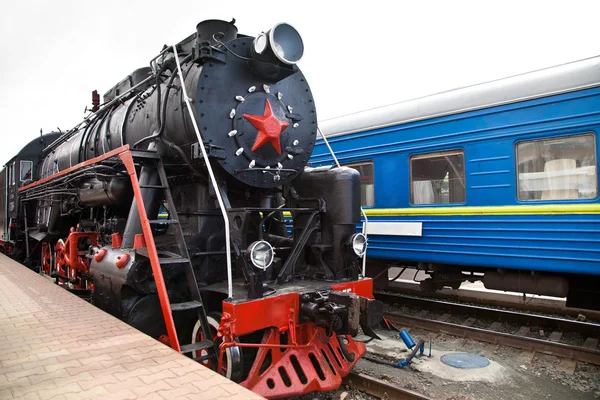 Old steam train is leaving a station — Stock Photo, Image
