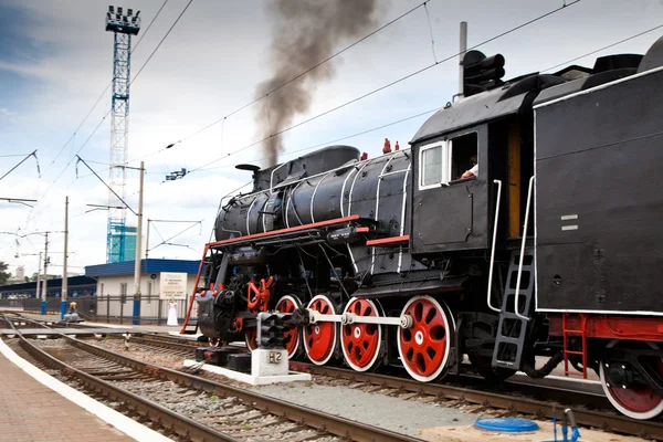 Alte Dampflok verlässt einen Bahnhof — Stockfoto