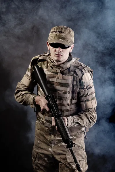 Soldier with a rifle on a black background — Stock Photo, Image