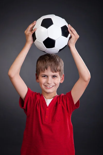 Χαριτωμένο αγόρι κρατάει μια μπάλα ποδοσφαίρου. μπάλα ποδοσφαίρου — Φωτογραφία Αρχείου