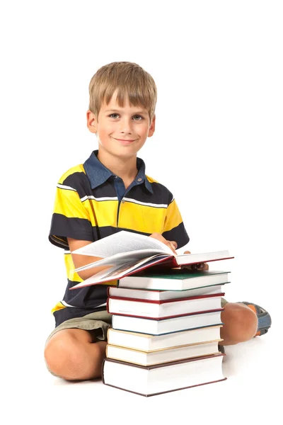 Schoolboy está sentado em livros — Fotografia de Stock
