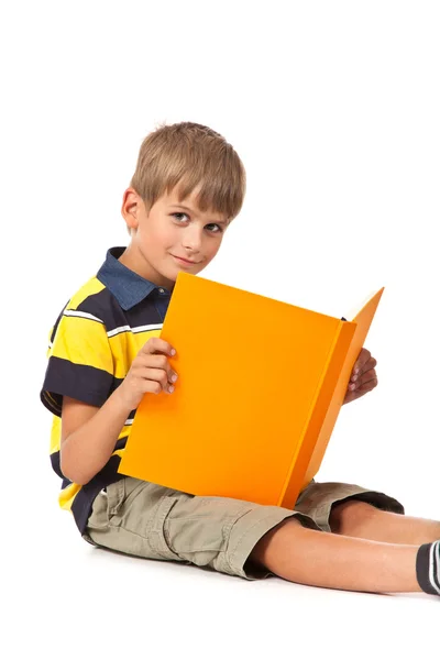 Schooljongen houdt een boek op wit — Stockfoto