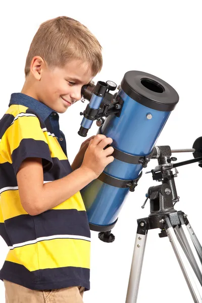 Ребенок смотрит в телескоп на белом фоне — стоковое фото