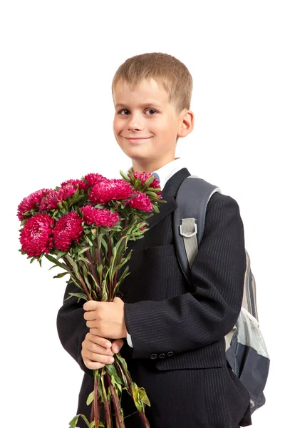男子生徒は花を持っています。学校に戻る — ストック写真