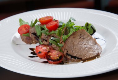 Beef medallions served with balsamic sauce clipart