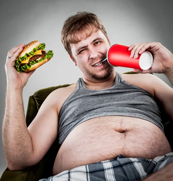 Gros homme manger hamburger — Photo