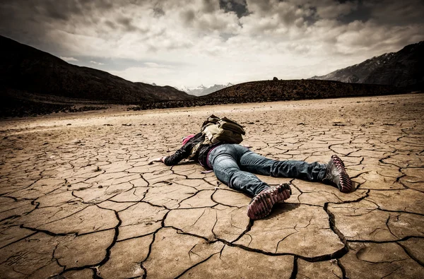 Людина лежить на сухому ґрунті — стокове фото