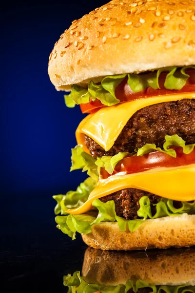 Smakelijke en smakelijk hamburger op een donkerblauw — Stockfoto