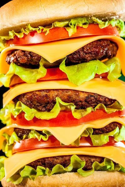 Hambúrguer saboroso e apetitoso em um escuro — Fotografia de Stock