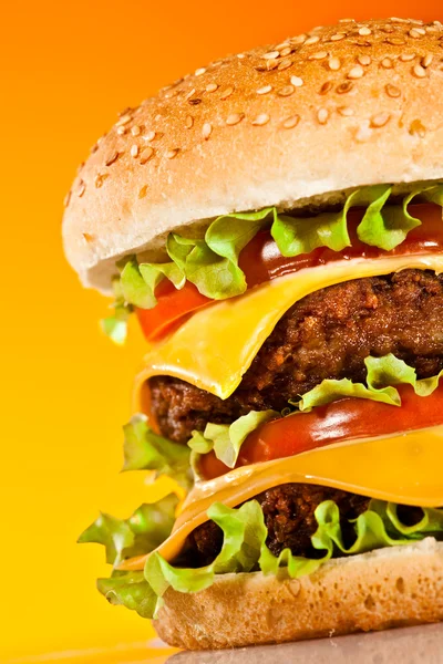 Tasty and appetizing hamburger on a yellow — Stock Photo, Image