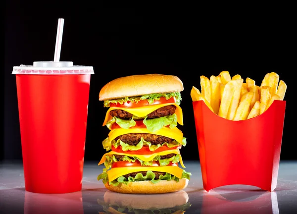 おいしいハンバーガーとフライド ポテト、暗色の上 — ストック写真