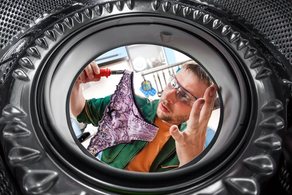 Trabalhador e uma máquina de lavar roupa — Fotografia de Stock