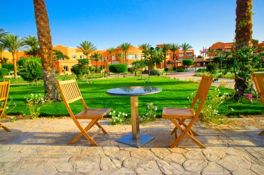 Resort and small lawn with chairs early morning. clipart