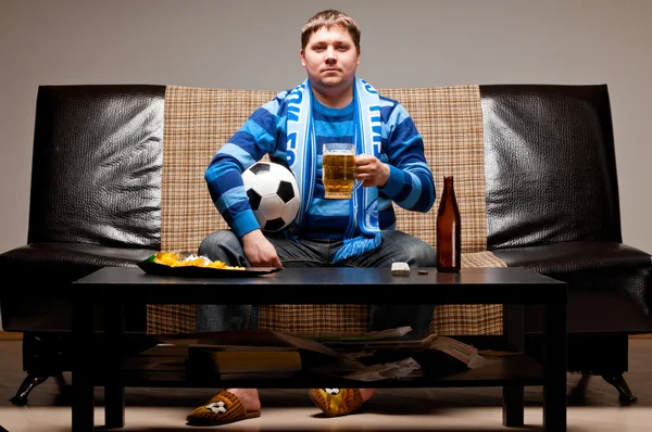 Футбольный болельщик на диване — стоковое фото