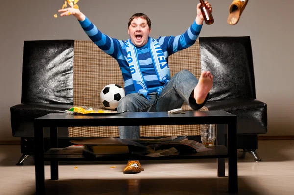 Soccer fan on sofa — Stock Photo, Image